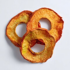 Three dried peach rings, stacked, on a white background