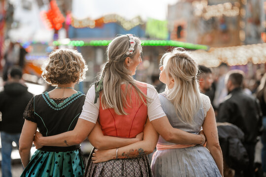 Bavarian folk festivals with three women in traditional dirndl costumes at Munich Oktoberfest G&auml;ubodenvolksfest Straubing and Regensburg Dultfest in Germany