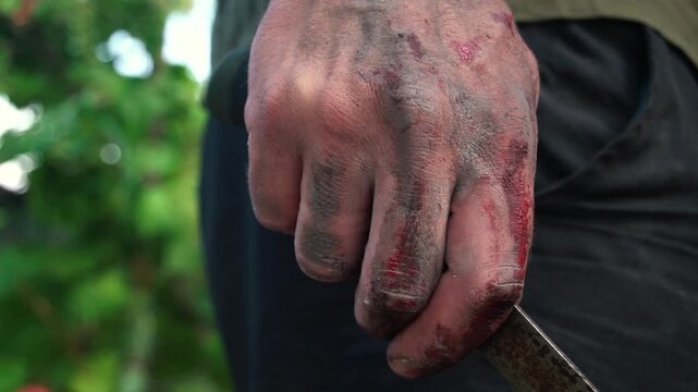 The maniac is waiting for his victim with a knife in his bloody hand. 