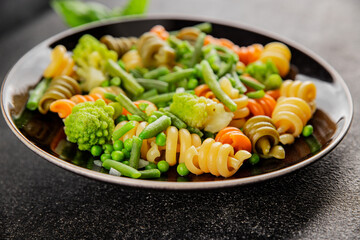 Trottole pasta vegetables green peas, green beans, kohlrabi cabbage, broccoli second course tasty snack fresh delicious gourmet food background on the table rustic food top view copy space