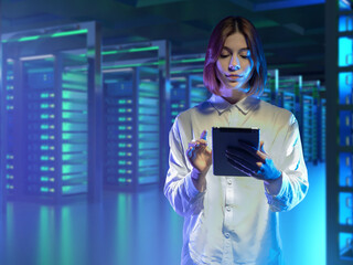 Woman with tablet in server room. System administrator for industrial companies girl with computer....