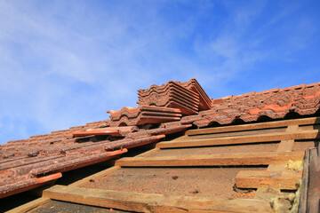 Roof renovation with insulation replacement. Stack of exposed tiles. old roof battens.