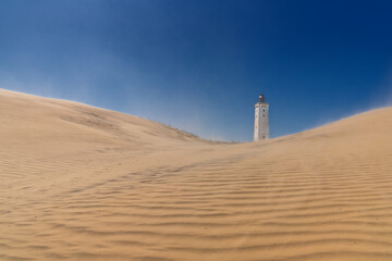 view of the sand dune and Rubjerg Knude lighthouse in Jutland in northern Denmark
