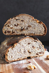 Artisan whole rye sourdough bread filled with crunchy walnuts and sweet raisins, featuring a rustic crust and airy texture