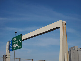 高架道路に立つ標識と東京の空