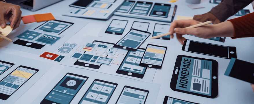 A vibrant workspace captures a collaborative design session focused on mobile application development with wireframes and sketches scattered across the table. SACTR