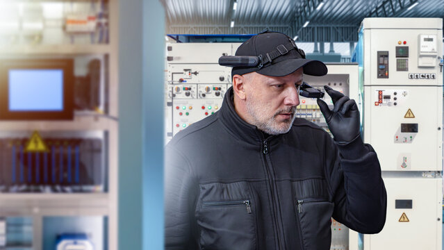 Engineer wearing smart glasses in control room with electrical panels, using augmented reality for industrial monitoring, innovation, technology. Engineering, Industry, Technology, Innovation.
