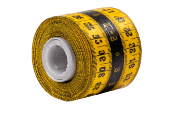 Rolled yellow measuring tape on black background Tailor tools measurement equipment