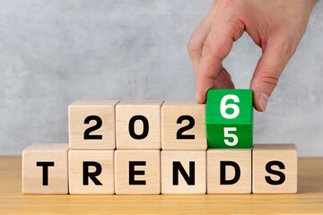 Trends in 2026. Business concept. Conceptual words. A hand turning a block from 2025 to 2026 and...