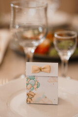 Baby Shower Favor Box with Teddy Bear Design, Balloons, and Glassware on a Decorated Table, Soft Pastel Colors, Celebratory Theme