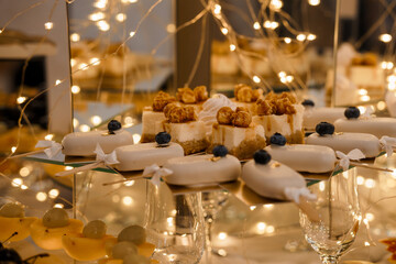 Elegant Dessert Display with Cheesecake Bites, Glazed Pastries, Blueberries and Twinkling Lights:...