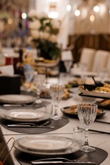 Elegant Wedding Reception Table Setting with Crystal Glasses and Gold Accents, Luxurious Dinner Scene, Warm Lighting and White Decor