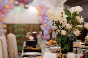 Elegant Wedding Reception Table Setting with White Flowers and Colorful Balloon Backdrop, Luxury Banquet, Celebration Decor, Soft Focus.