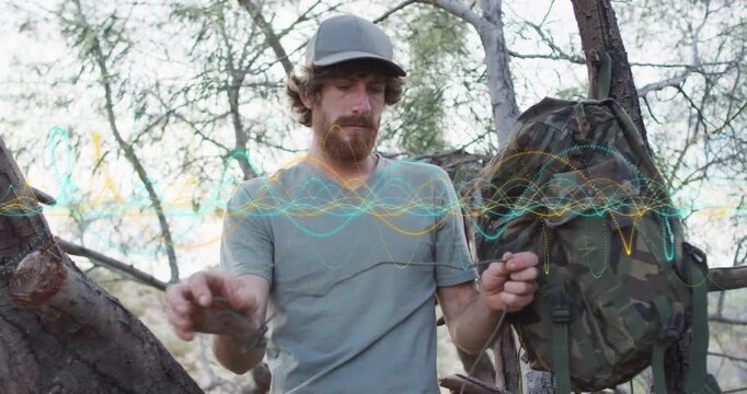 Outdoors enthusiast retrieving paracord from camouflage pack and measuring rope length for survival