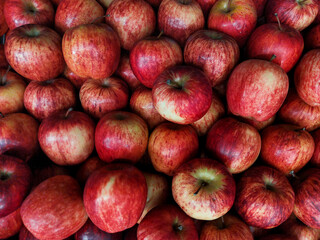 Fresh red striped apples stacked together, showing natural organic texture, healthy nutrition, and vibrant color. Perfect for diet, vegan lifestyle, and fresh fruit background