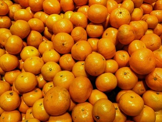 Fresh orange tangerines piled together at the market. Bright, juicy citrus fruits full of vitamin C, perfect for a refreshing snack, healthy juice, or seasonal harvest produce display