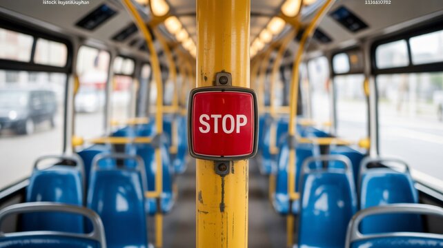Bus interior with rows of blue seats and a bright yellow pole with a red stop button