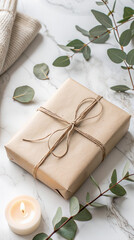 Elegant gift wrapped in brown paper with green leaves on a marble surface and cozy candlelight view