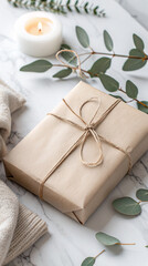 Elegant gift wrapped in brown paper with natural twine on marble background eucalyptus and candle