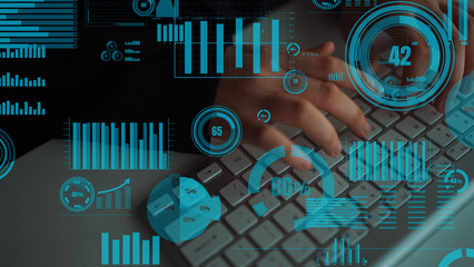 A close-up view of hands typing on a keyboard surrounded by digital graphs and metrics. This image portrays data analysis in a modern office setting, highlighting technology and innovation. Xenic