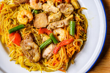 Plate of Tasty Spicy Singapore Noodles With Meat and Vegetables
