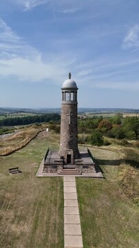 Crich, Derbyshire, England - August 13 2025: Aerial drone footage of Crich Stand war memorial on a hilltop with countryside views. Vertical video.