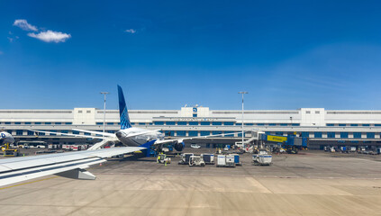 Athens, Greece. Passenger aircraft parked at the terminal of Athens International Airport, ground crew and equipment upon the tarmac