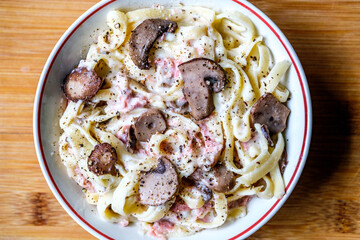 London UK, August 30 2025,  Bowl of Classic Ham and Mushroom Tagliatelle Pasta Meal With No People