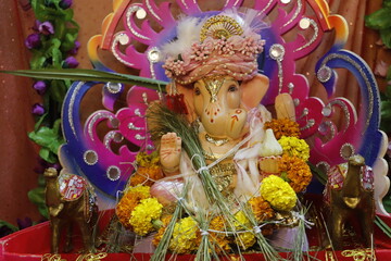 Ganapati festival celebration at home with a beautifully decorated Ganesh idol, flowers, lights, and traditional offerings, symbolizing devotion, prosperity, and cultural heritage in a festive atmosph
