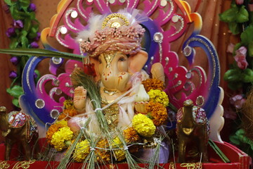 Ganapati festival celebration at home with a beautifully decorated Ganesh idol, flowers, lights, and traditional offerings, symbolizing devotion, prosperity, and cultural heritage in a festive atmosph