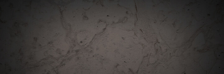 Dark wide panoramic background. Natural rock with patterns on the surface. Dolomite texture. Solid stone background for design. Shaded texture with vignette.