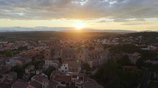 Sunset drone video of Altafulla, Spain - Aerial shot rising up for view of the small town in Tarragona, Spain with a castle perched at the high point of the neighborhood 