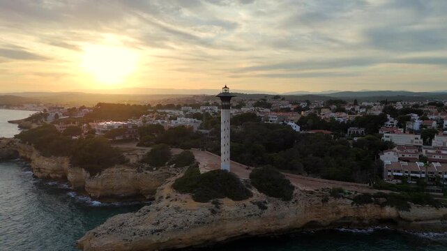 Torredembarra Lighthouse in Spain aerial drone video zooming out at evening 