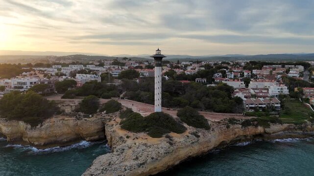 Torredembarra, Spain drone video of modern lighthouse along coast at sunset