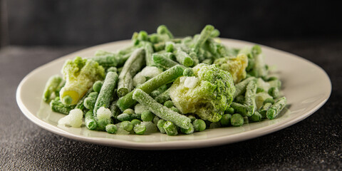 Frozen green vegetables green peas, broccoli, string beans, kohlrabi kale tasty snack fresh food background on the table rustic food top view copy space keto and paleo diet vegan and vegetarian food