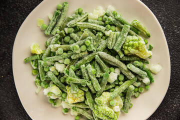 Frozen green vegetables green peas, broccoli, string beans, kohlrabi kale tasty snack fresh food background on the table rustic food top view copy space keto and paleo diet vegan and vegetarian food