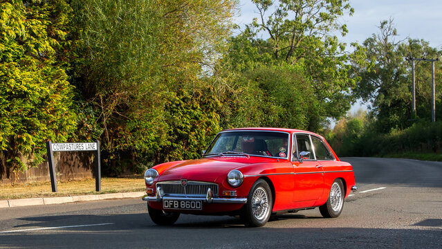Whittlebury,Norhants,UK - Aug 23rd 2025: 1966 red MG B gt  car driving on a British road