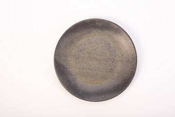 Beautiful ceramic plate placed on a white background, selective focus. Top view.