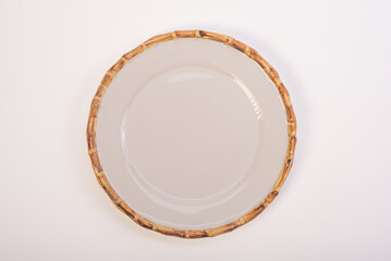 Beautiful ceramic plate placed on a white background, selective focus. Top view.