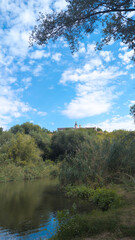 Saharna Monastery rising above the Saharna river and lush vegetation under a cloudy sky