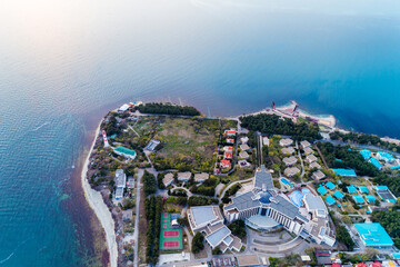Panorama of Gelendzhik resort at sunset from Black Sea. Aerial view. In foreground is Gelendzhik lighthouse. Caucasus Mountains at back.