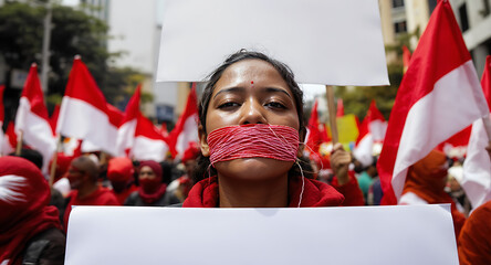 Woman with taped mouth symbolizing silenced voice and freedom of speech at a human rights protest