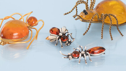 Baltic amber jewelry. Isolated yellow amber brooches in the shape of bugs. Vintage jewelry close up.