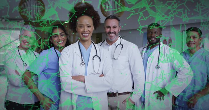 Medical team posing in hospital lobby while green molecular graphics emerging highlighting science