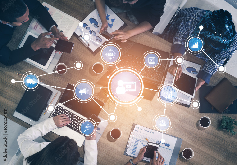 Poster a top view of a diverse group of professionals working together in a modern office, using laptops an