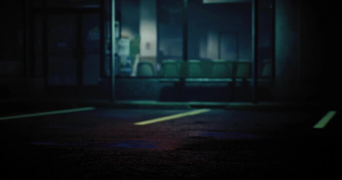 In a dimly lit parking lot, shadows stretch across empty spaces. A faint glow from nearby establishments creates an eerie ambiance. The atmosphere feels quiet and deserted at night.