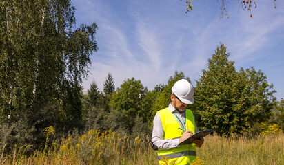 Forestry inspector studying the condition of trees in the forest. Work Ecologist. Eco control....