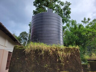A drinking water storage tank placed on an old and poorly maintained concrete platform. The...