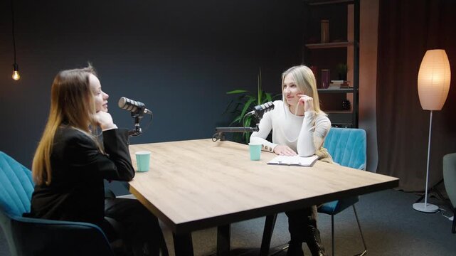 Two dynamic women discuss business strategies in an inviting podcast studio setting