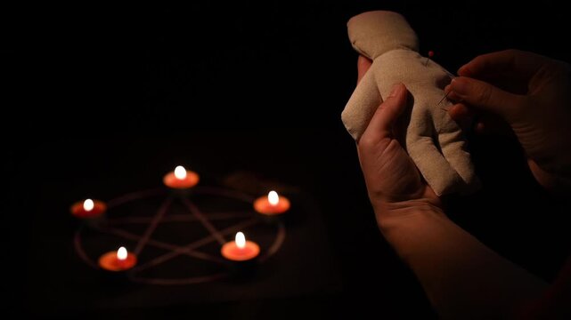 Woman sticking pins into voodoo doll. 